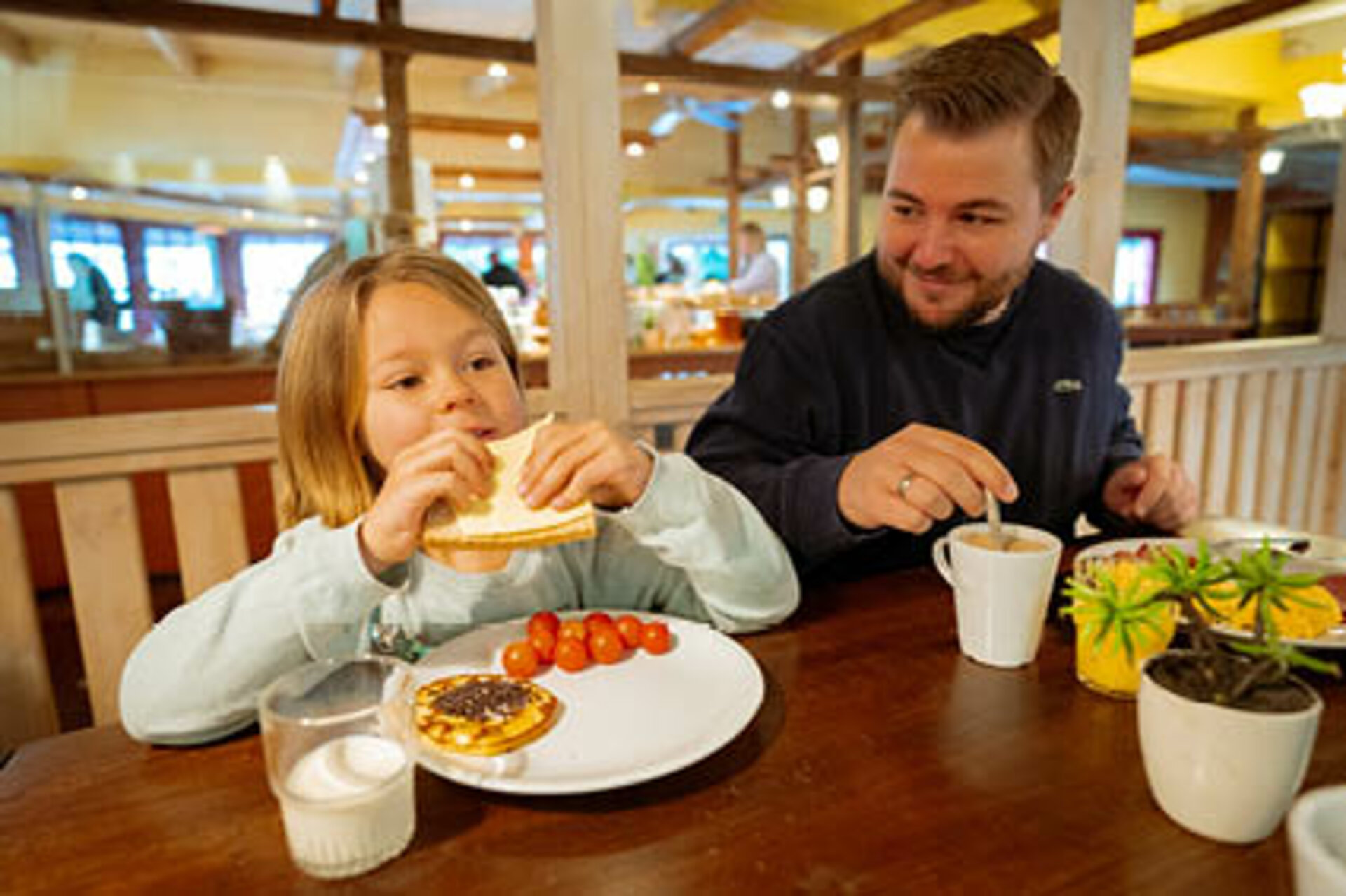 Tochter und Vater genießen das reichhaltige Frühstücksbuffet. 