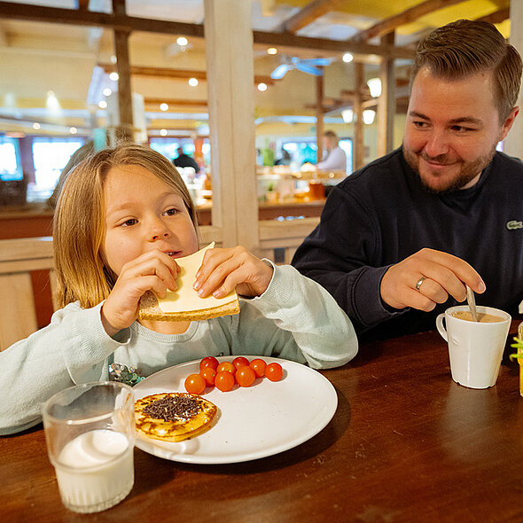 Im Restaurant lässt sich eine Mädchen Pancakes und Toast vom typisch amerikanischen Frühstücksbuffet schmecken. 