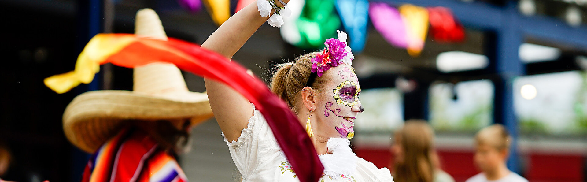 Beim FORT FUN Event Mexican Summer tanzt eine bunt geschminkte Künstlerin.