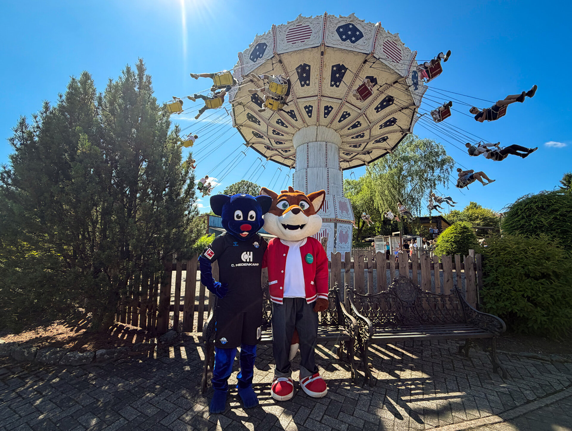 Die Maskottchen Holli und Funny haben Spaß vor dem Riesenrad im Freizeitpark FORT FUN.