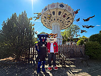 Die Maskottchen Holli und Funny haben Spaß vor dem Riesenrad im Freizeitpark FORT FUN.