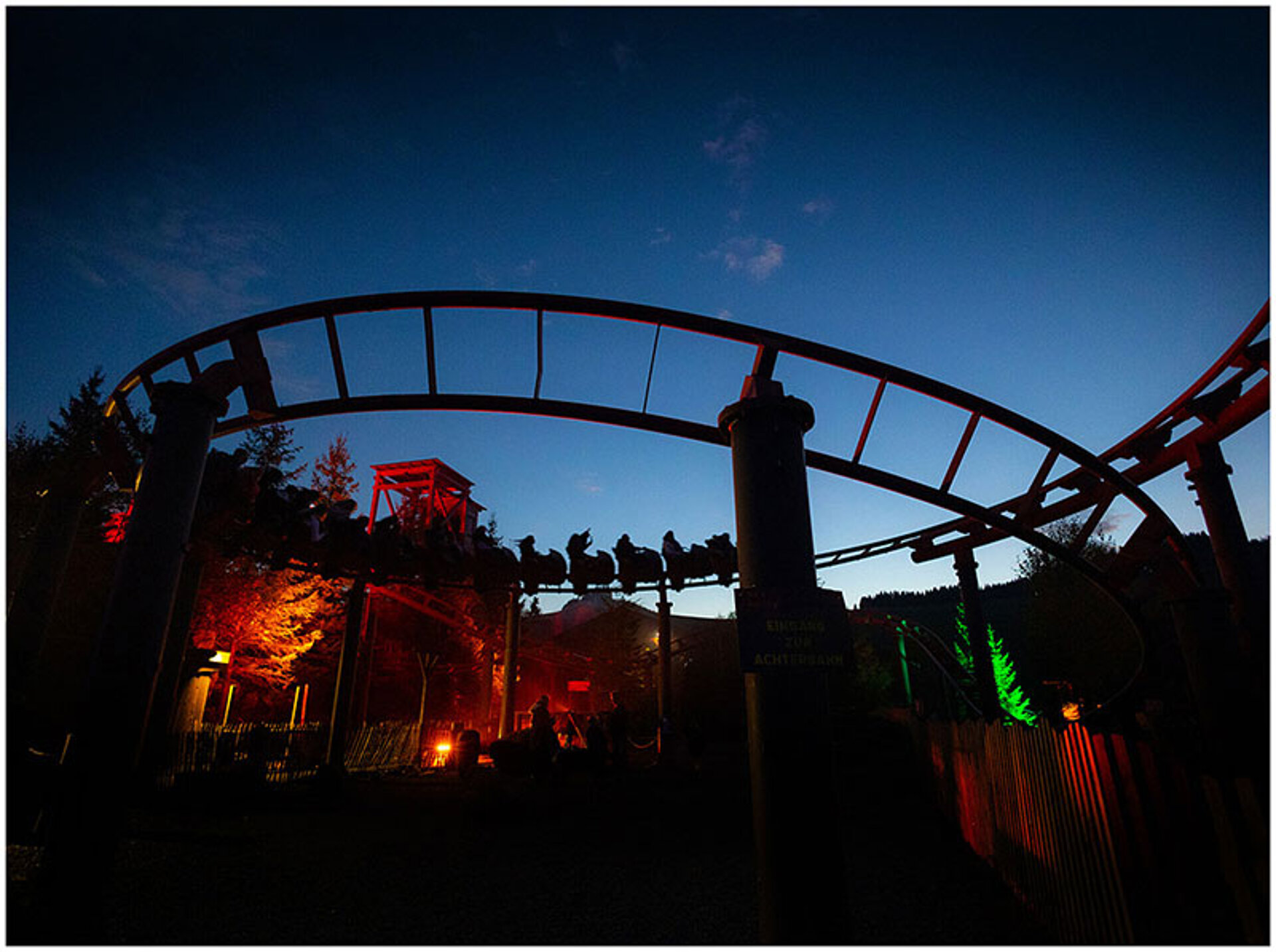 Die Devils Mine - eine Familienachterbahn - fährt in der Dämmerung.