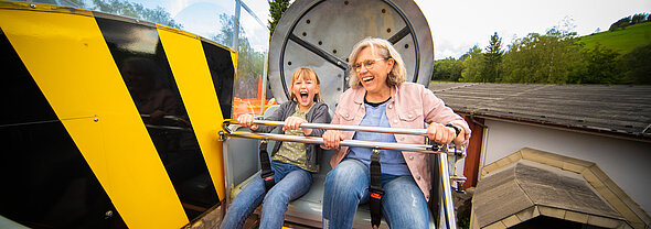 Enkelin und Oma genießen die Fahrt mit dem Airobot im FORT FUN.