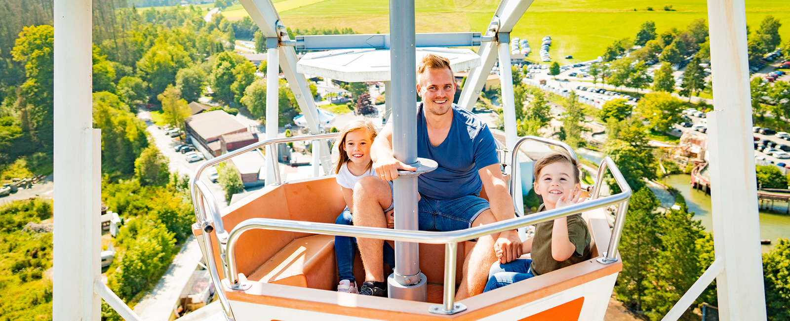 In der Riesenrad Gondel des Big Wheel hat der Papa mit seinen Kindern viel Spaß.