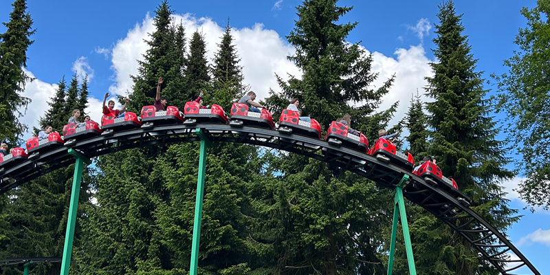 Die Marienkäferbahn fährt mit fröhlichen Gästen den ersten Berg rasant herunter.