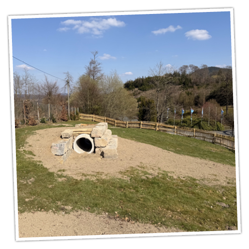 Der Hundespielplatz bietet verschiedene Spielelemente, wie zum Beispiel eine große Röhre zum Durchlaufen.