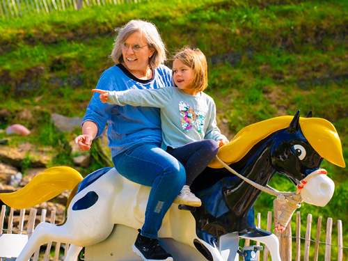 Oma und Enkelin entdecken, bei der Pferdereitbahn, Yakari beim Ritt auf Kleiner Donners Rücken.
