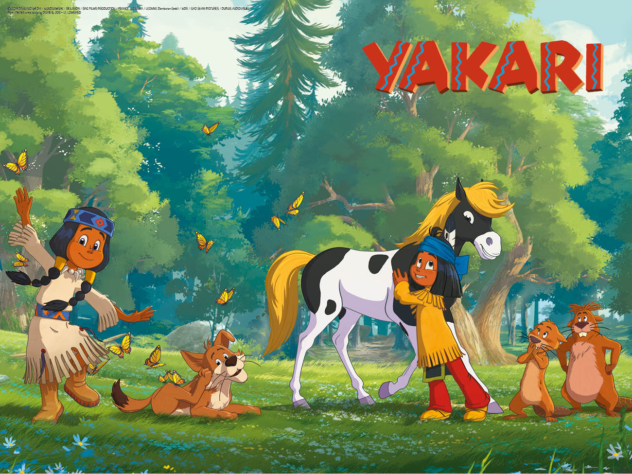 Yakari, kleiner Donner und seine Freunde tanzen auf der grünen Wiese mit den Schmetterlingen.